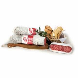 Salame tipo Milano su un tagliere con alcune fette tagliate e un cestino di pane